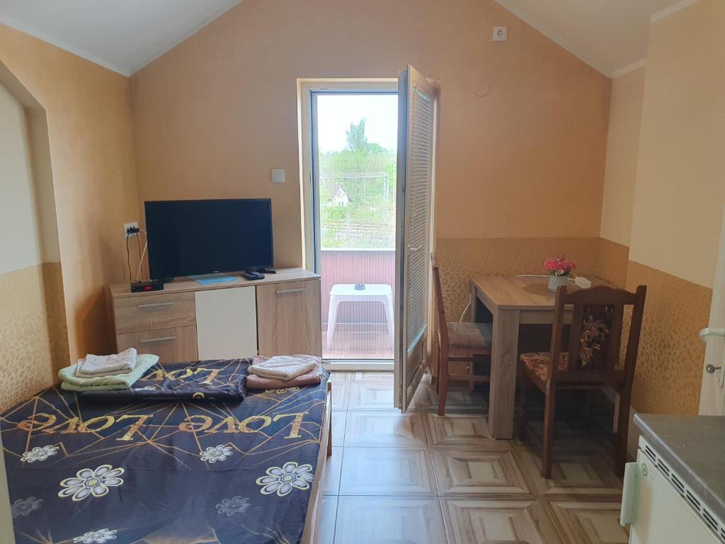 a room with a bed and a table and a television at Double Lux Aparrment A1 in Pancevo in Pančevo