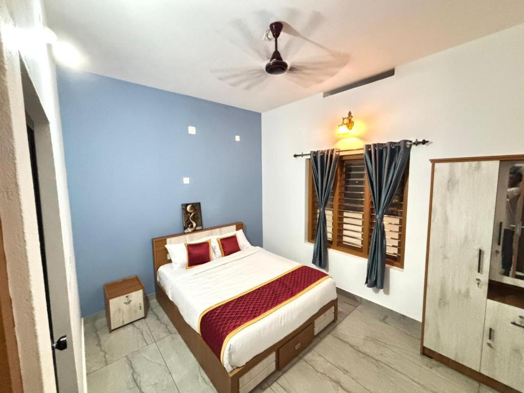 a bedroom with a bed and a ceiling fan at Zak Holidays Wayanad in Wayanad