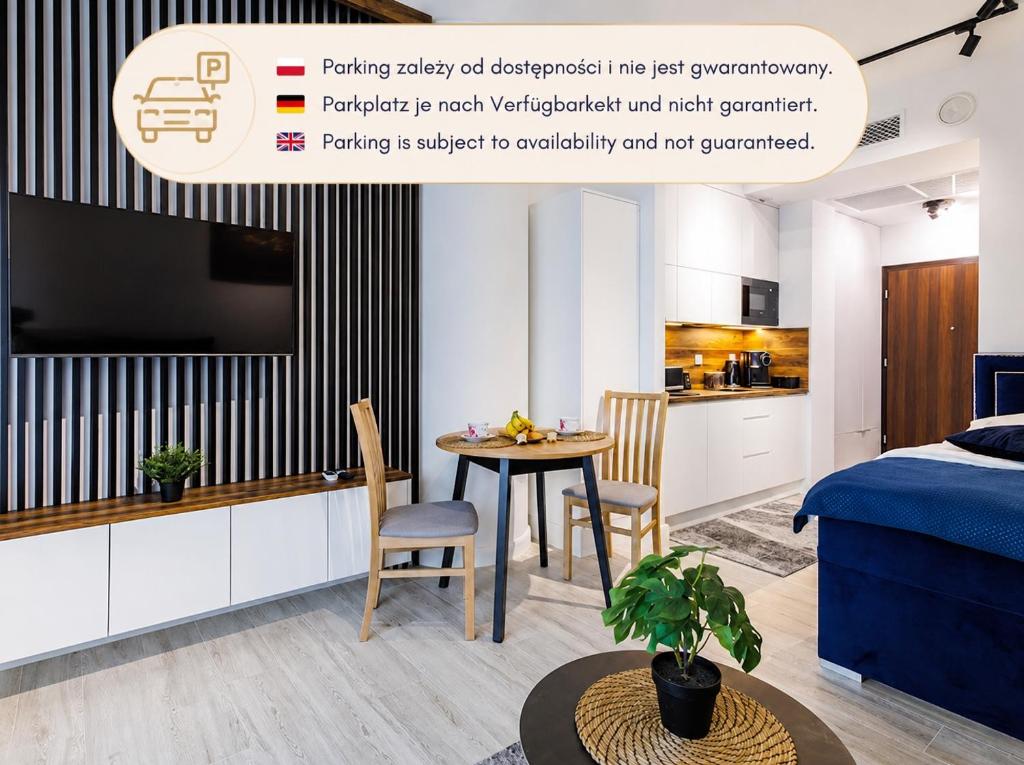 a room with a bed and a table and a kitchen at Apartament Hanza Tower 218 in Szczecin