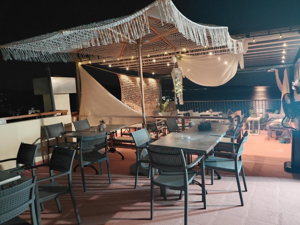 una sala da pranzo con tavoli, sedie e un ombrellone di Polydor a Tolo