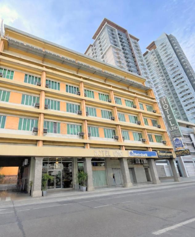 a building on a street with tall buildings at Hotel Uno in Davao City