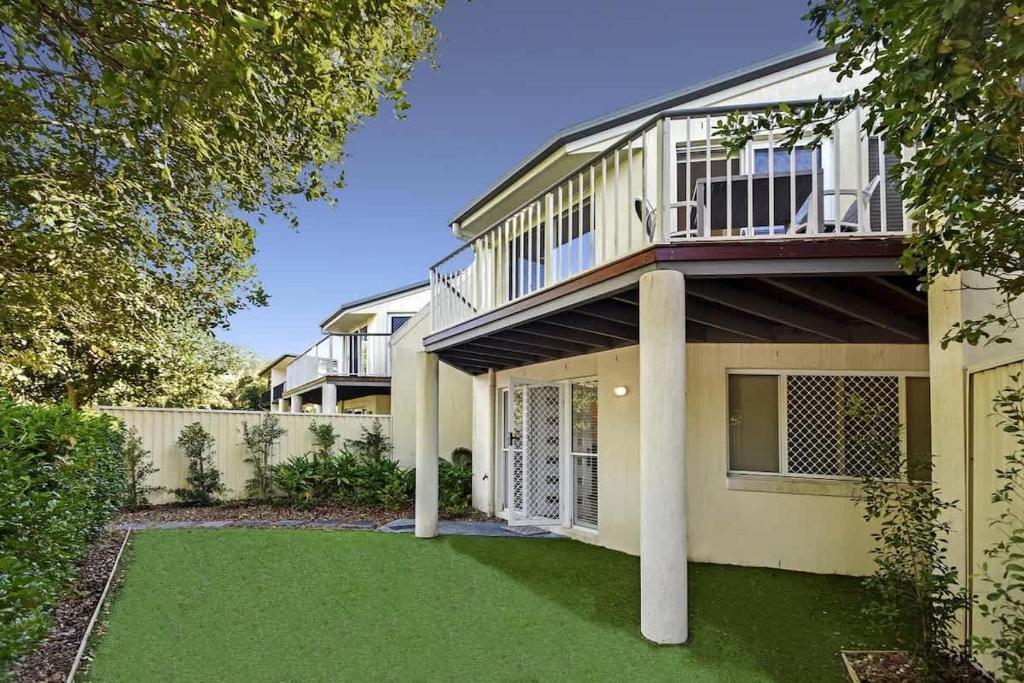 a house with a balcony on top of a yard at Advance Place in Sunrise Beach