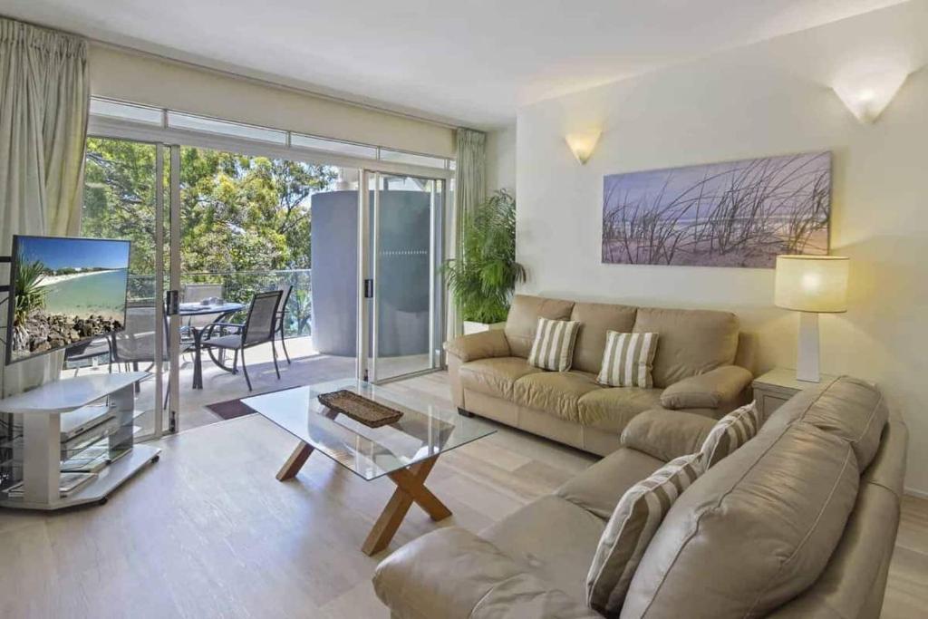 a living room with a couch and a table at Park Cove Apartments in Noosa Heads
