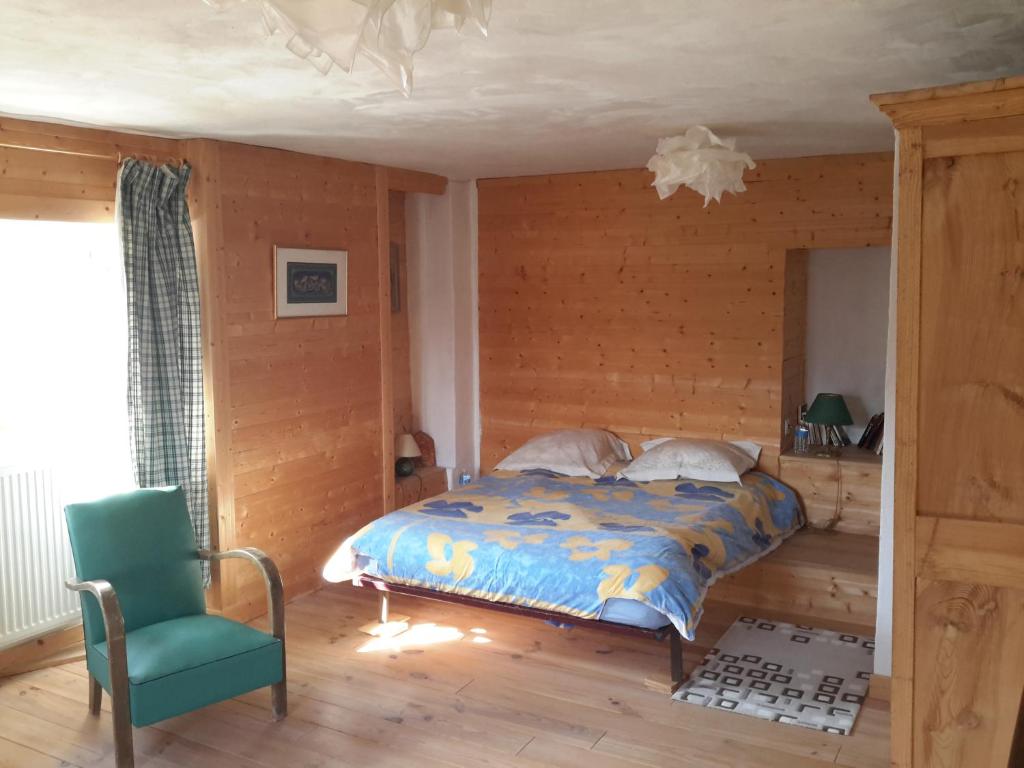1 dormitorio con 1 cama y 1 silla verde en Casa Arnera en Andon