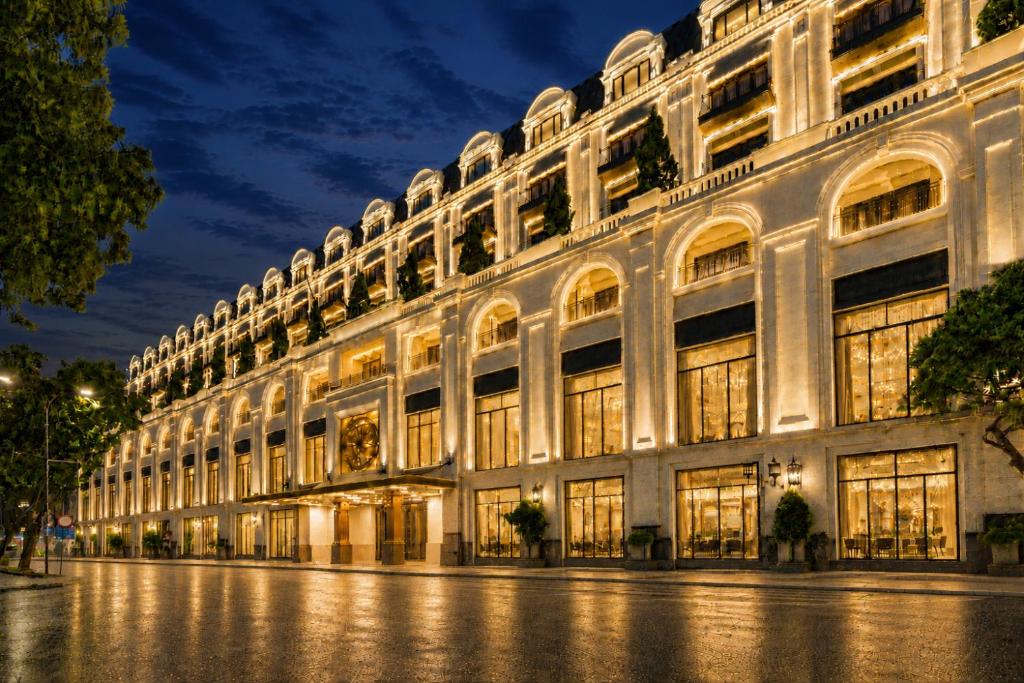 a large white building at night at The Theodore Hanoi in Hanoi