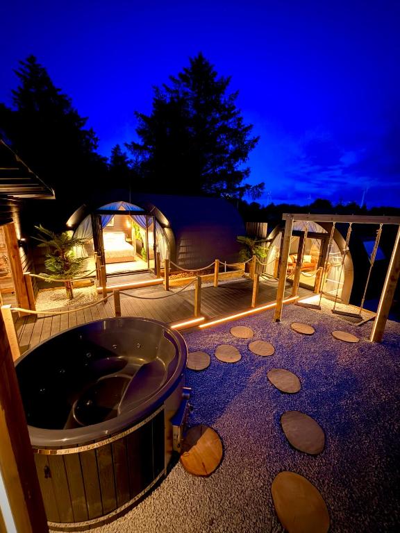 a deck with a hot tub and a tent at The Secret Garden Glamping Cornwall in Cury