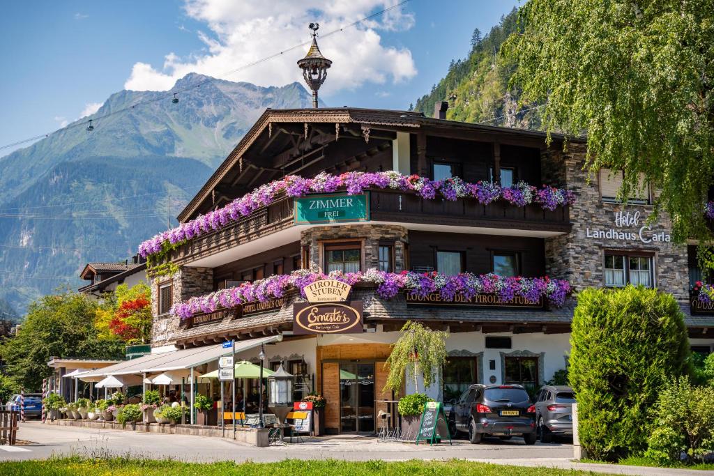 a building with flowers on the front of it at Hotel Landhaus Carla in Mayrhofen