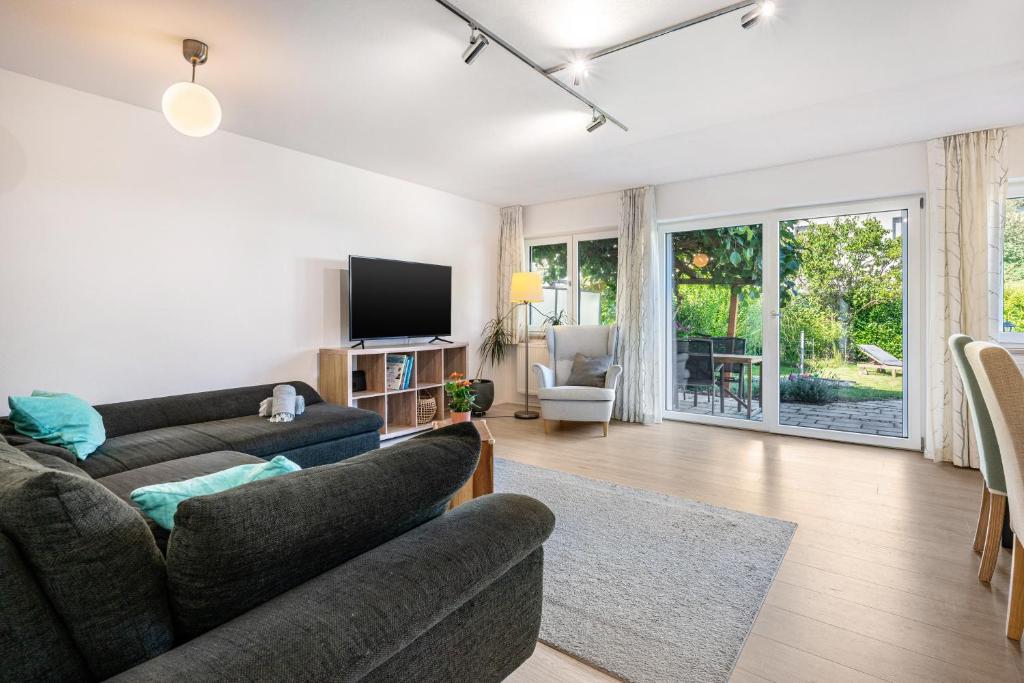 a living room with a couch and a tv at Charmantes Haus mit eigenem Garten in Prien am Chiemsee