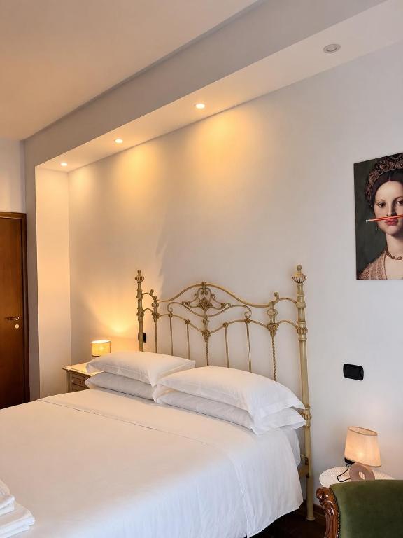 a bedroom with a large bed with white sheets at Archivio 32 in Caserta