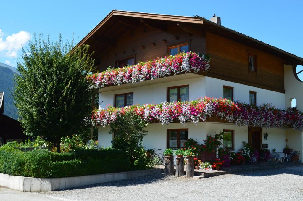 ein Haus mit Blumen auf der Seite in der Unterkunft Appartments Hofer in Stumm