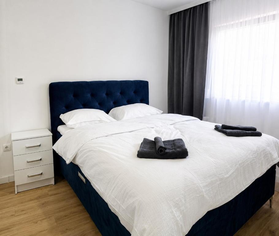 a bedroom with a large bed with a blue headboard at Central Аpartment Foca with garage in Foča