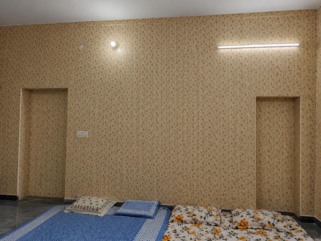 a room with two beds and a wall at Theprefabnest in Rishīkesh