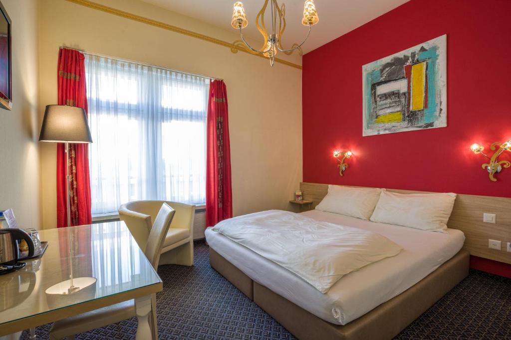 a hotel room with a bed and a table at Hotel Ambassador in Solothurn