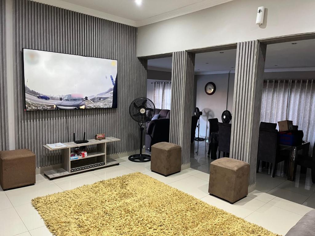 a living room with a flat screen tv on the wall at Regent House in Durban