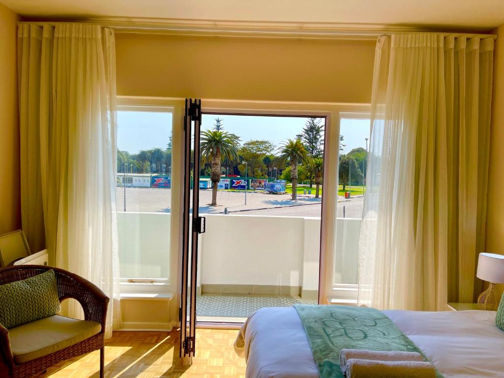 a bedroom with a bed and a sliding glass door at Loewenhoff Seaview Suite 2 in Swakopmund