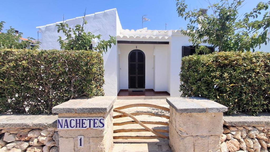 a small white house with a sign that says miracles at Nachetes 1 in Cala Blanca