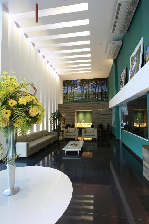 a lobby with a vase of flowers on a table at Uchôa Teresina Hotel in Teresina