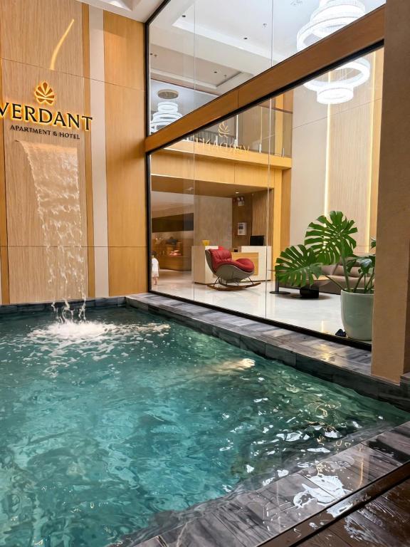 a swimming pool in the lobby of a hotel at Verdant Apartment & Hotel in Dong Hoi
