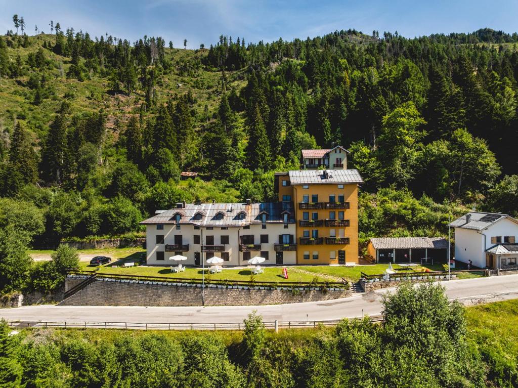 a large yellow building on the side of a mountain at Residenza Panarotta - Vetriolo(1500m) in Levico Terme