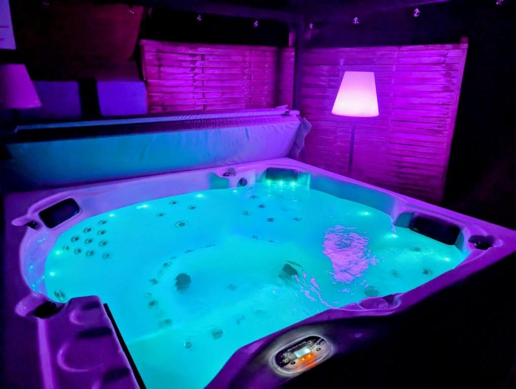a jacuzzi tub in a room with a lamp at Le Chalet Cozy & Spa in Wildersbach