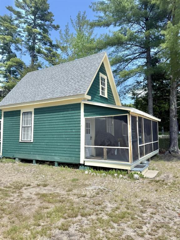 a green house with a large screened porch at FRIENDLY INN LIMIT 5 cottage in North Sebago
