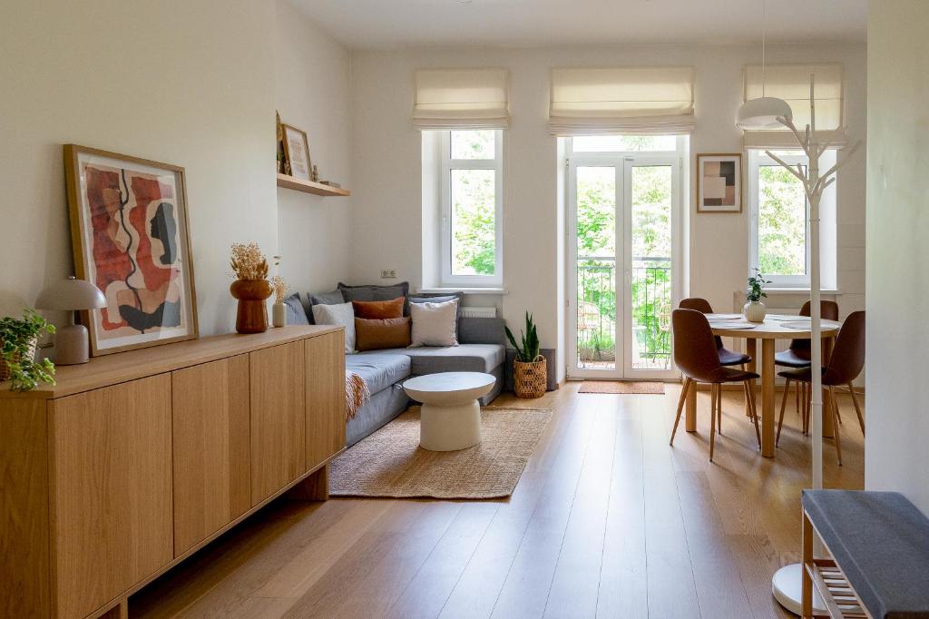 a living room with a blue couch and a table at Historic Karaimai Street Balcony Apartment, Trakai, Lithuania in Trakai