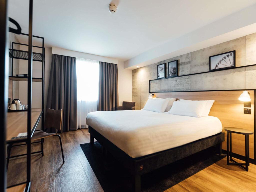 a hotel room with a large bed and a window at ibis Coleraine Riverside in Coleraine