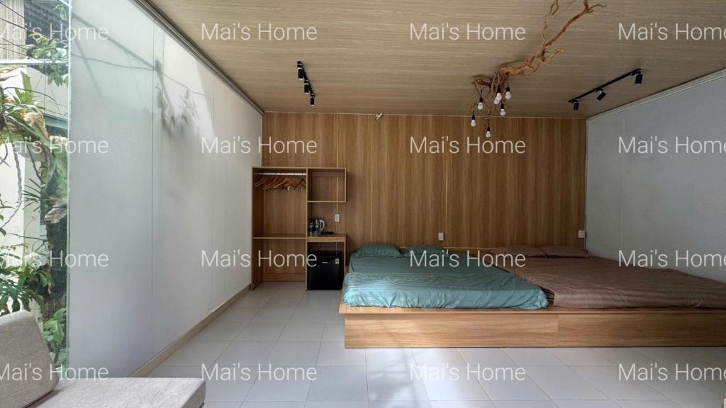a bedroom with a bed in the corner of a room at Mai Home in Ấp An Mỹ