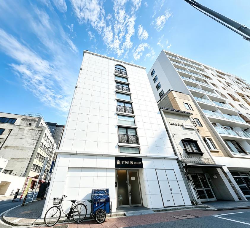 a white building with a bike parked in front of it at ETSU 悦 HOTEL Chuo Ward Tokyo 1-2BDR House in Tokyo