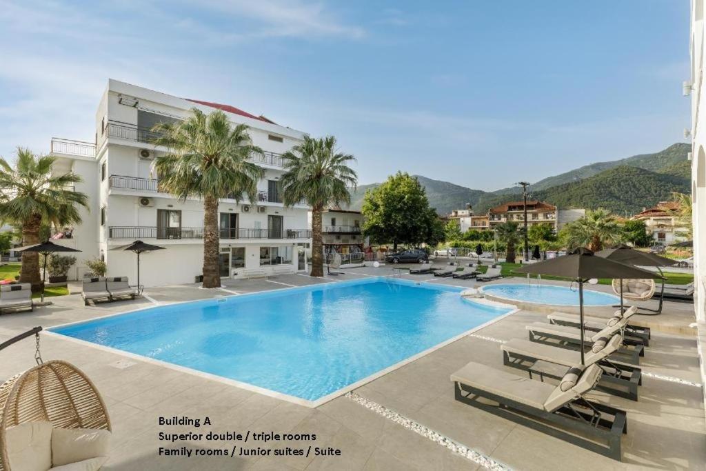 a hotel with a swimming pool and lounge chairs at Stavros Beach Hotel in Stavros