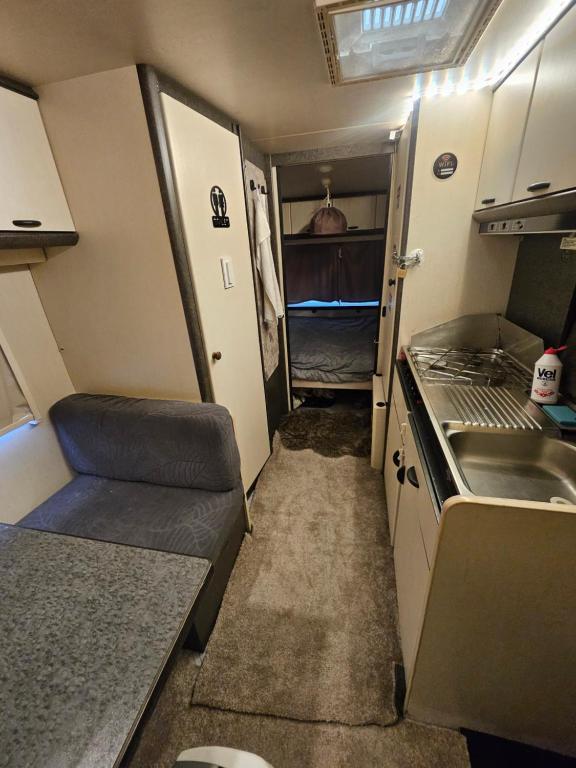 a small kitchen in an rv with a sink at Full Service Caravan 1 in Albertslund