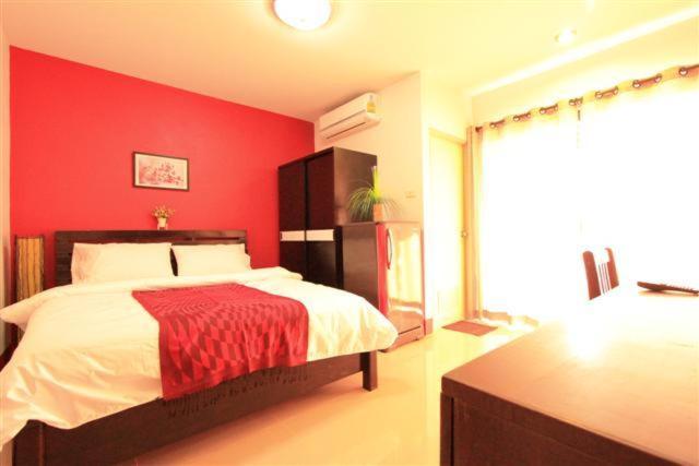 um quarto vermelho com uma cama com uma parede vermelha em See View Place em Chiang Rai