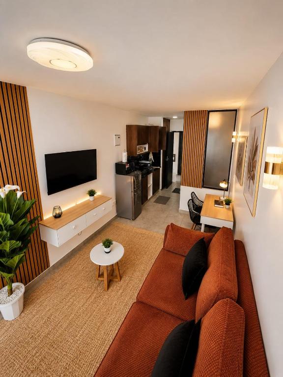 a living room with a couch and a tv at Ongata Rongai Pool Studio Near Nairobi National Park and giraffe center in Ongata Rongai 