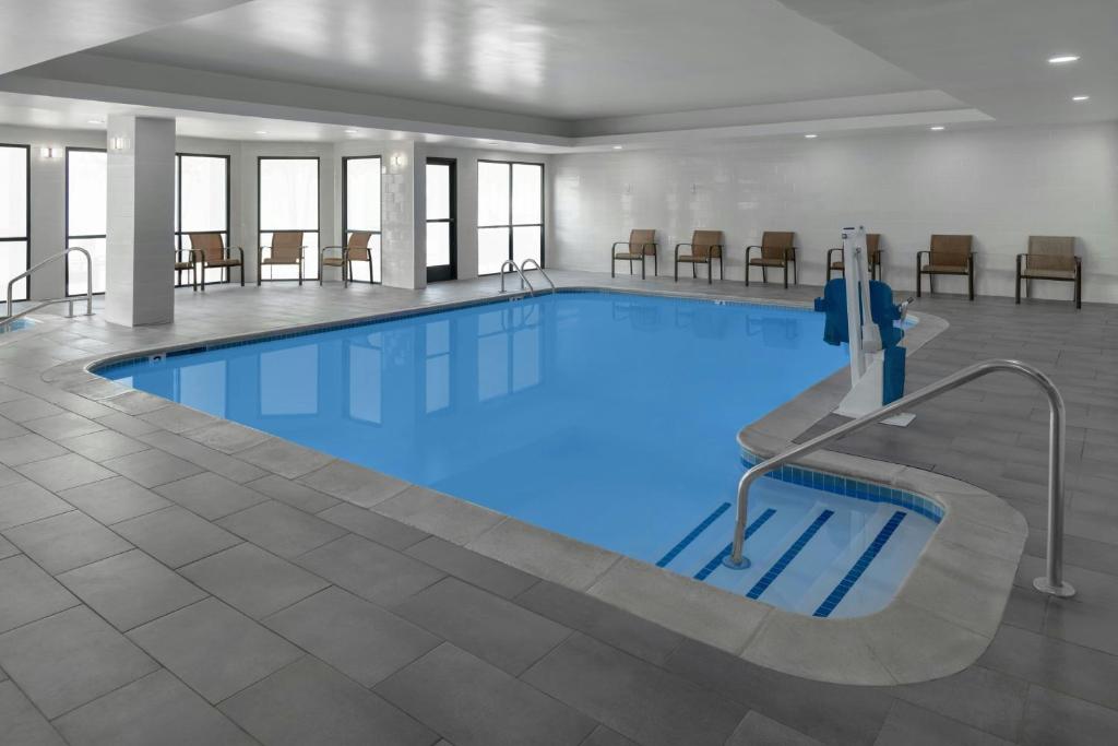 a large swimming pool with blue water in a building at Courtyard by Marriott Flint Grand Blanc in Flint