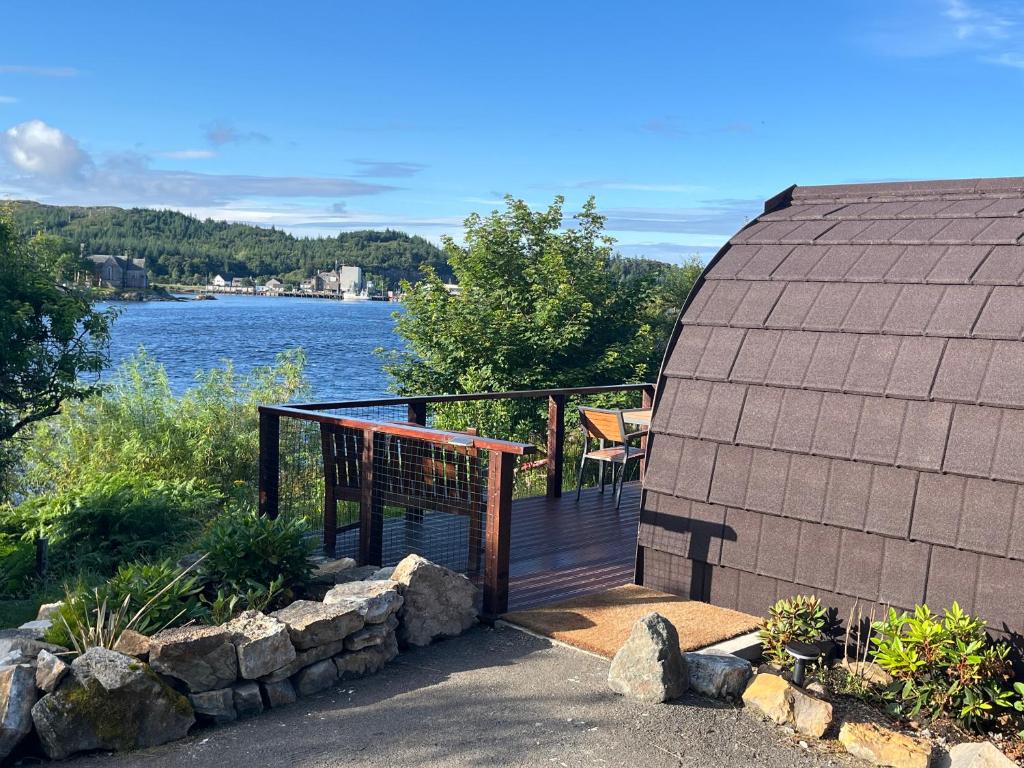 a house with a deck with a view of the water at Inverpod in Lochinver
