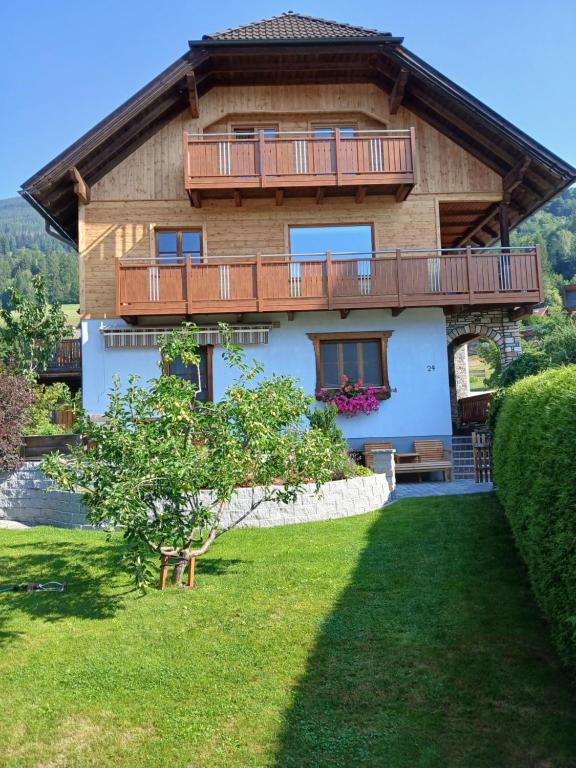 a house with a balcony and a yard at Ferienwohnung Holzer in Sankt Michael im Lungau