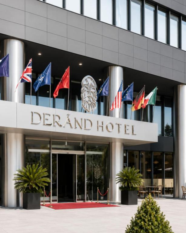 a group of flags in front of a hotel at Derand Hotel in Prishtinë