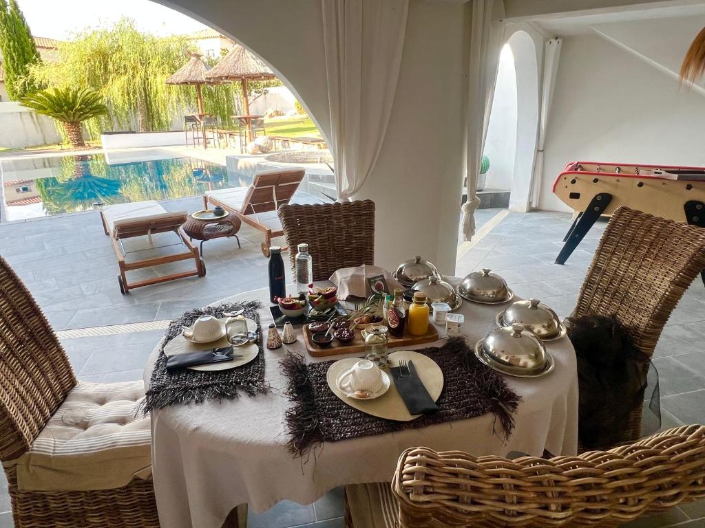 a table with food and tea on it in a patio at Lofts avec Jacuzzi privatif - Spa Romantique - Bouzigues in Bouzigues