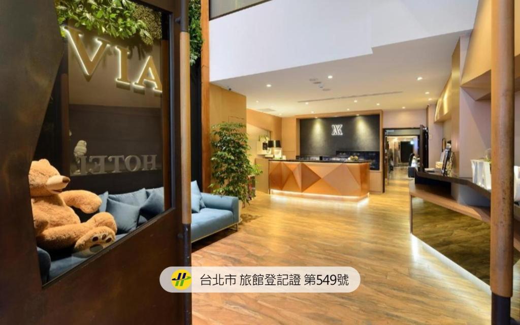 a lobby of a hotel with teddy bears on a couch at Via Hotel Taipei Station in Taipei