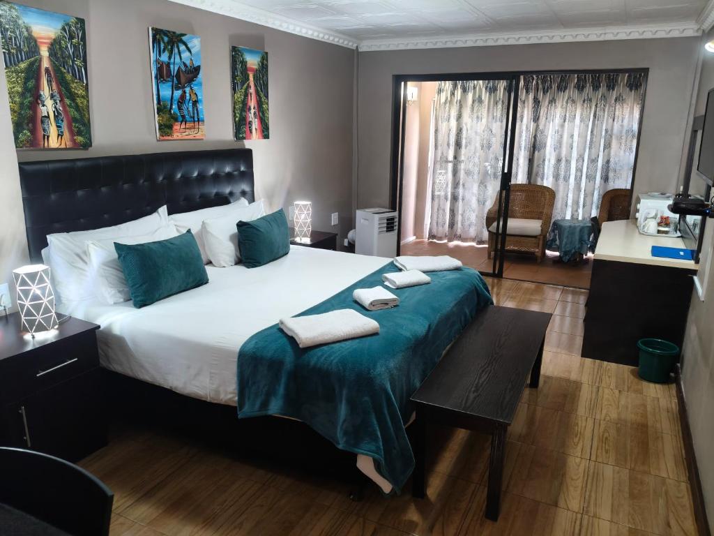 a bedroom with a large bed with blue pillows at Blyde Lodge in Graskop