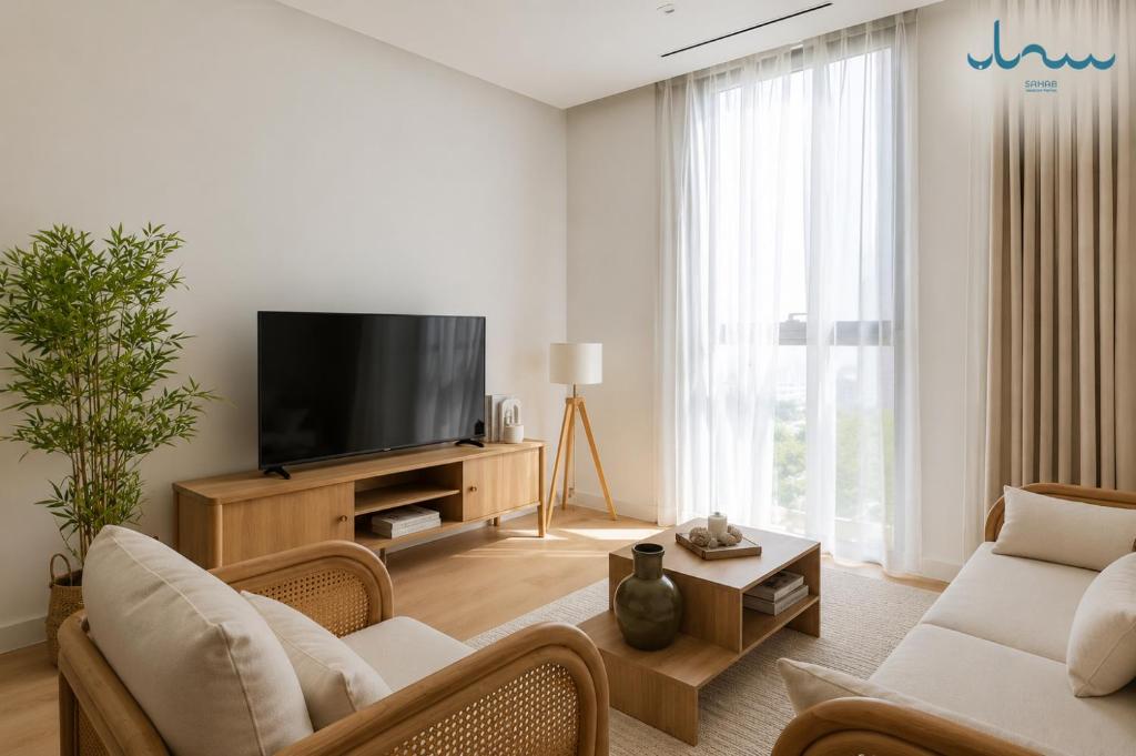 a living room with a couch and a tv at Sahab - Rustic One BR Apt in Ḩiz̧āyib az Zānah