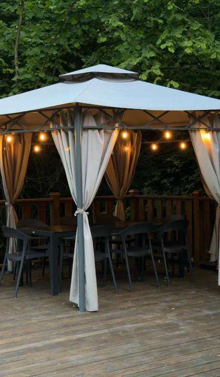 a white tent with chairs and tables and lights at Садиба Володар in Kosiv