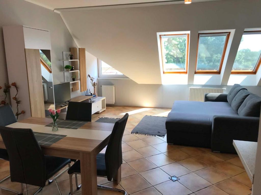 a living room with a blue couch and a table at Kincs apartman in Győr