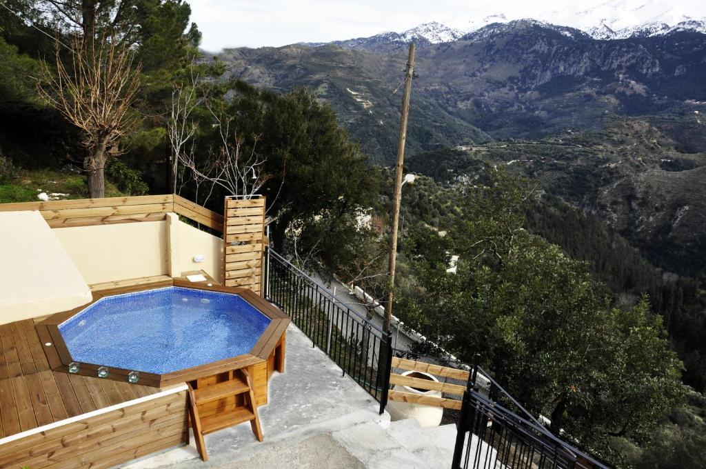 a hot tub on a balcony with a view of mountains at Villa Lakki Heated round pool Jacuzzi in Lákkoi