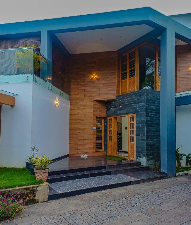 a house with a front porch with a porch at KRISHNASHILa in Varkala