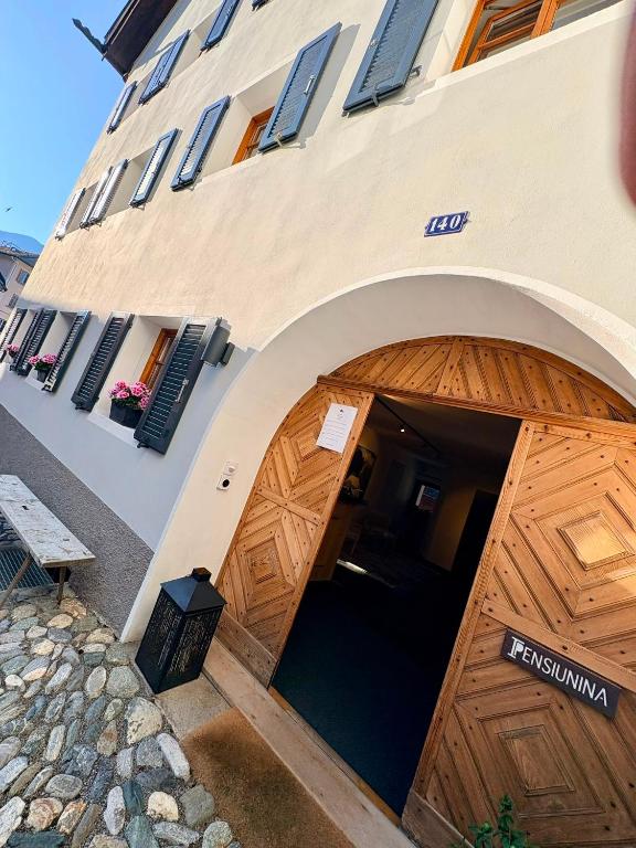 a building with a large wooden garage door at Pensiunina - Pension - Sent in Sent