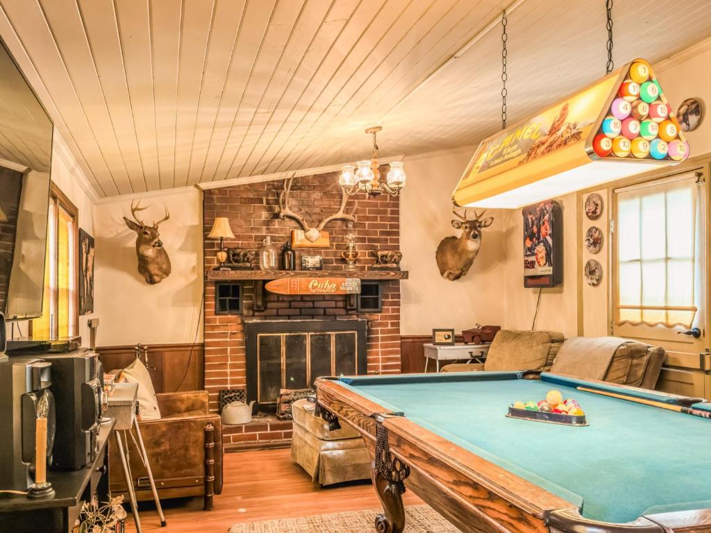 a living room with a pool table and a fireplace at A Charming Nature Retreat in Greensboro