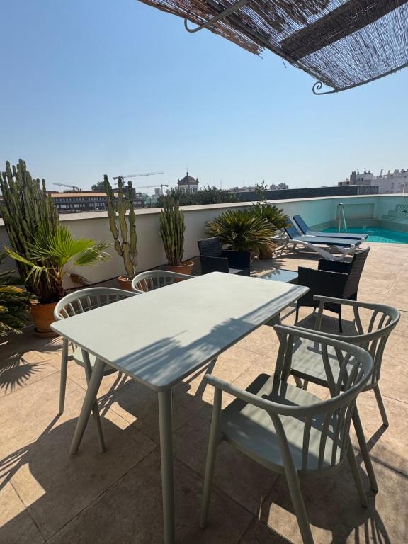 a table and chairs on the roof of a building at Apartamentos RG Suites Jardines de Murillo in Seville