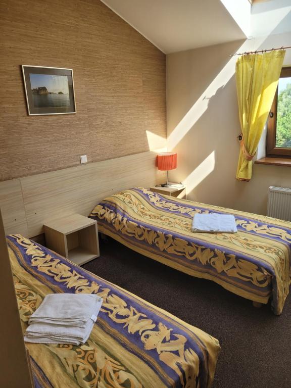a hotel room with two beds and a window at RV kavinė motelis in Salaperaugis