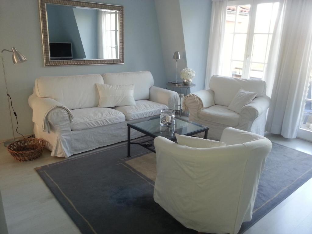 a living room with a couch and chairs and a table at Morgensünn am Strand in Kühlungsborn